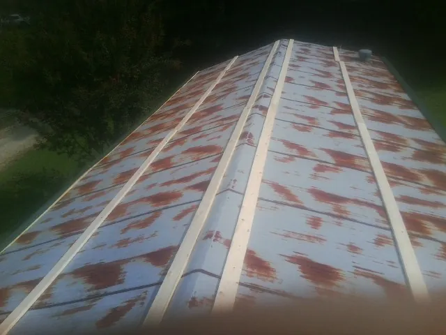 Rusted metal roof panels with new wood purlins before replacement — Storm Damage Roof Repair in Redford by Roofing Brothers