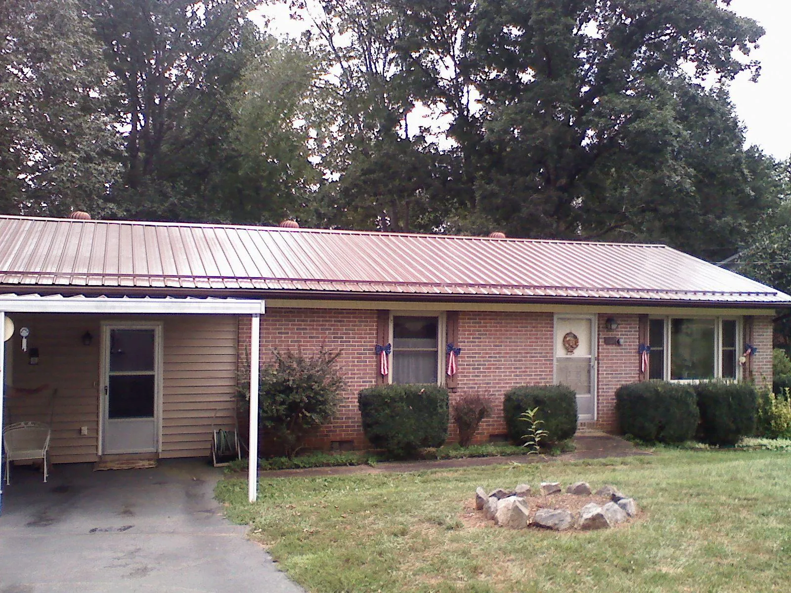 Bronze metal roof and carport on a brick ranch home — Roof Repair work by our crew in Redford