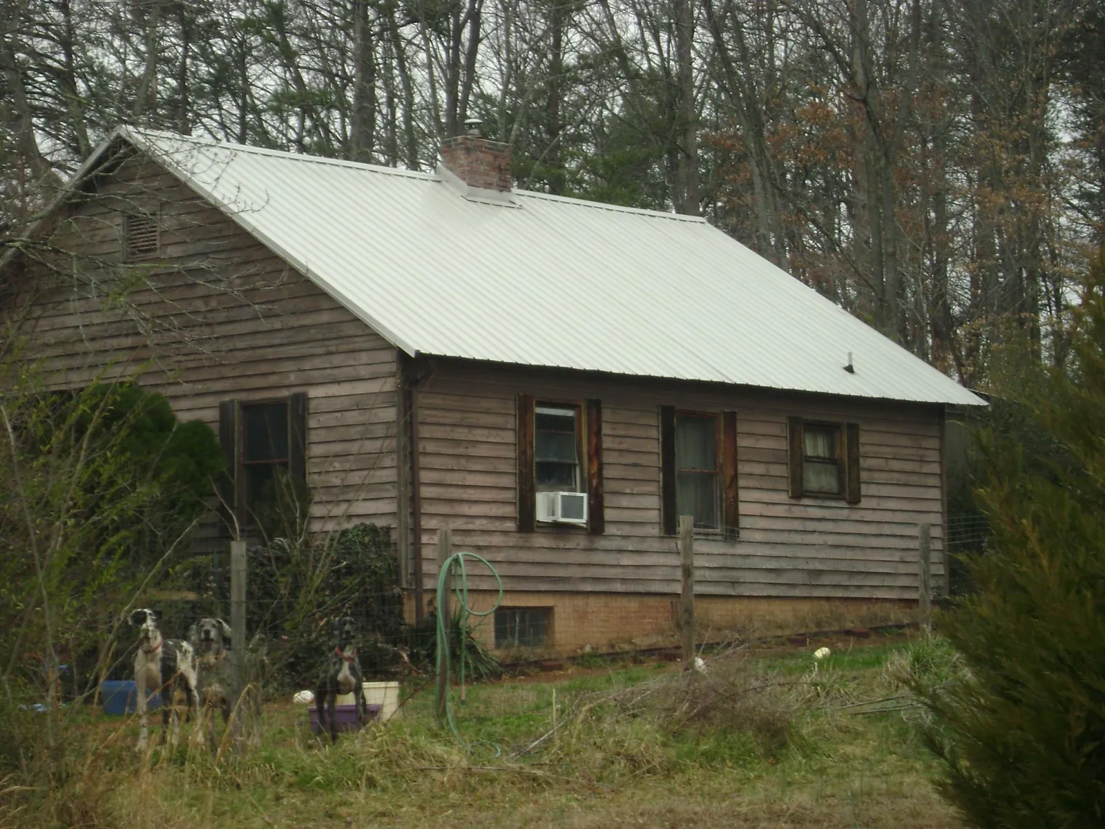 White metal roof on an old wood sided farmhouse, from a Metal Roof Installation job in Redford